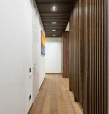 A sleek, contemporary hallway featuring wood paneling and modern lighting fixtures.